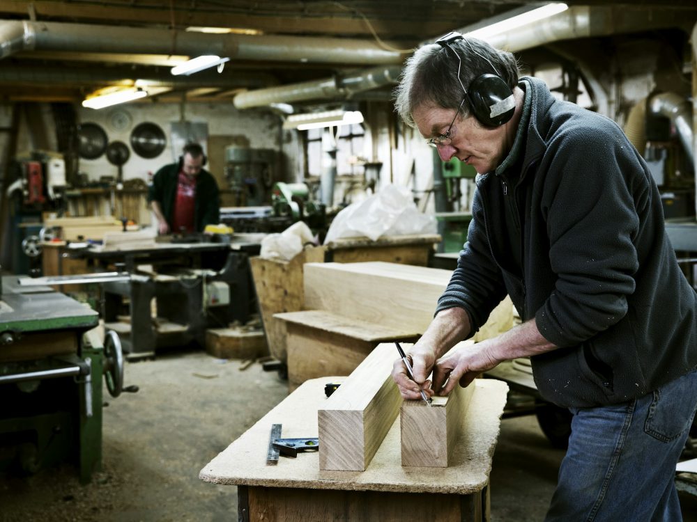 A man working in a furniture maker's workshop.